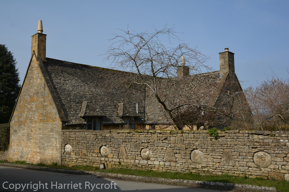 Staddle stones embedded in a handsome Cotswold stone wall in Snowshill